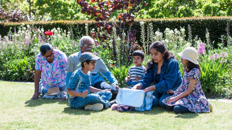 A family share a picnic on the lawn at Bodnant Garden, Conwy, Wales